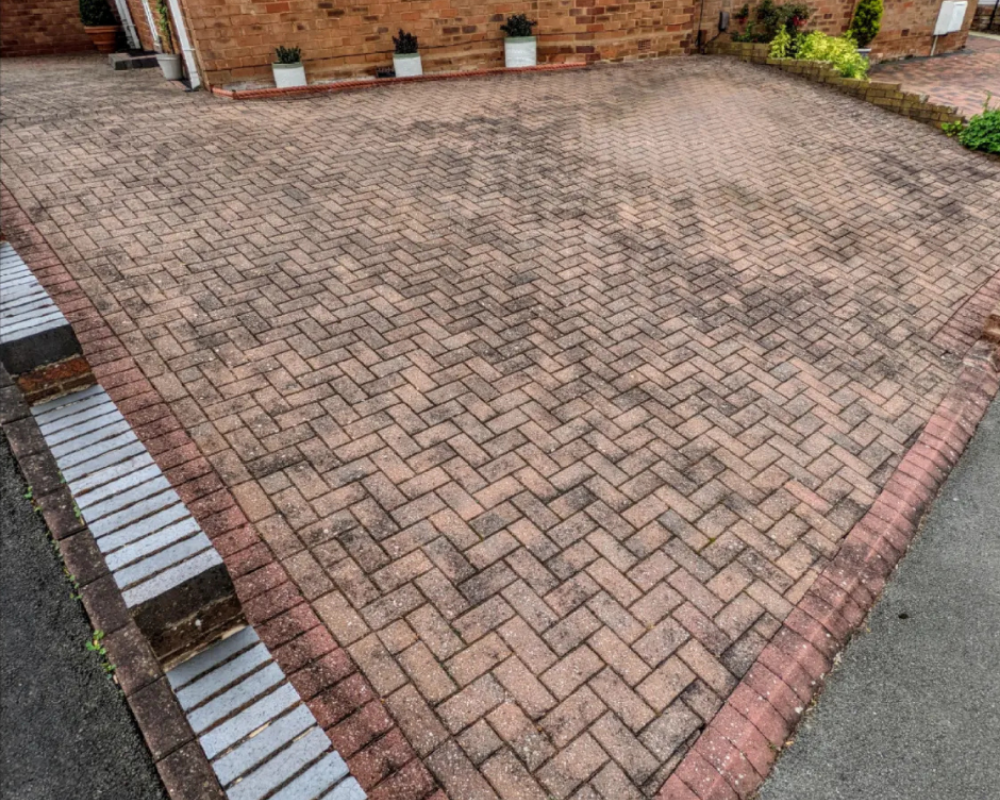 Large block paving driveway with dirt, tyre marks and weathering before SmartGuard restoration.