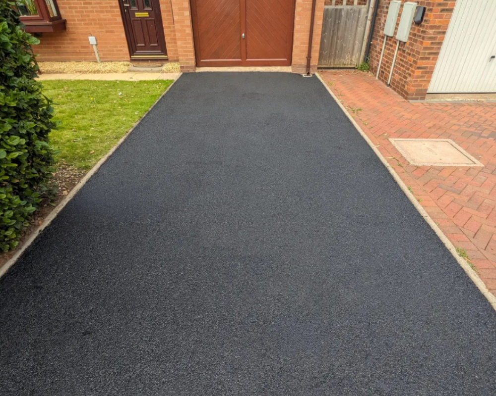 Tarmac driveway restored and recoloured by SmartGuard, showing a rich, even black finish.