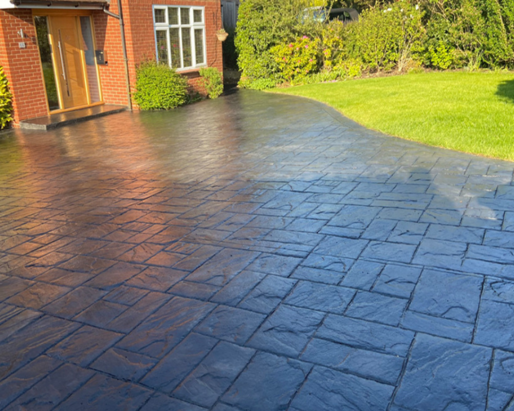 Imprinted concrete driveway restored by SmartGuard with a rich, glossy finish after sealing.