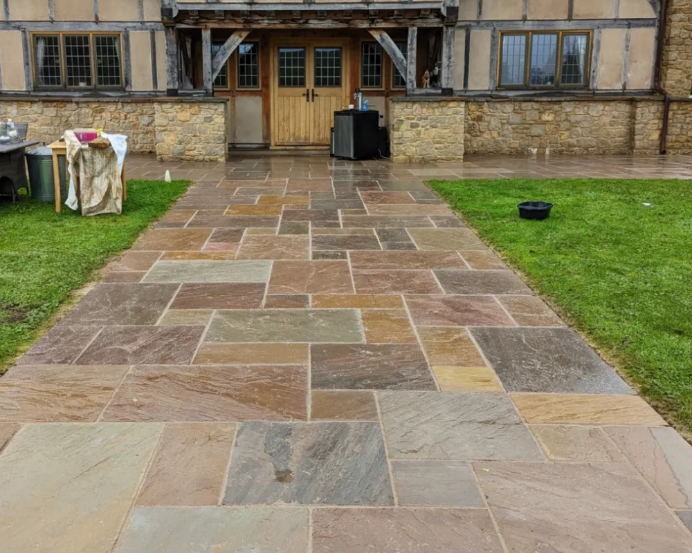 Natural stone patio freshly cleaned and sealed by SmartGuard, showing enhanced colour and clarity.