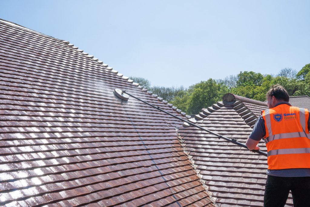 Professional roof cleaning in progress using a rotary surface cleaner, showing SmartGuard’s safe moss removal and roof restoration service.
